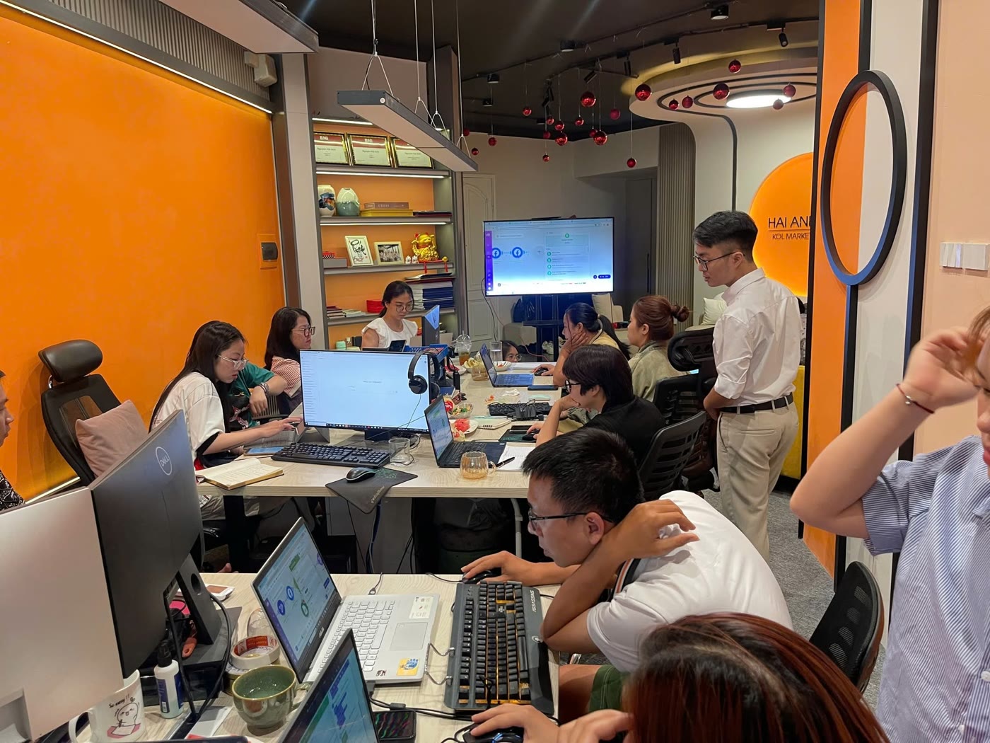Toàn cảnh lớp thực hành Make.com: học viên làm trên laptop, màn hình lớn chiếu dây chuyền tự động